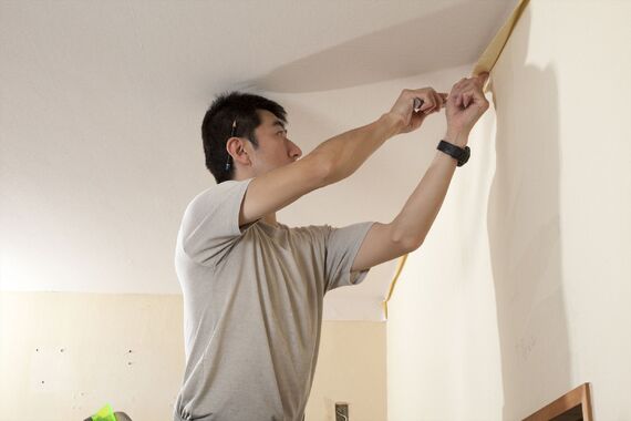 クロス張替え作業の微調整を行うスタッフ